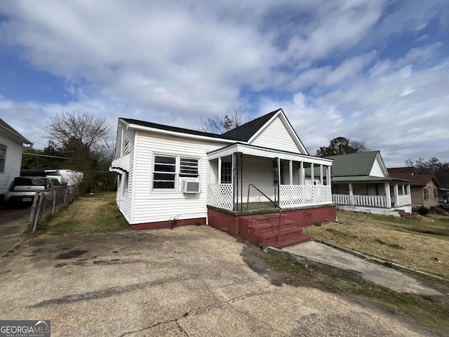 bungalow-style home featuring covered porch, a front yard, and cooling unit