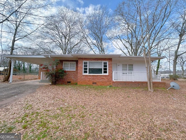 ranch-style home with a porch, an attached carport, aphalt driveway, brick siding, and crawl space