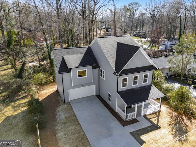 view of front facade with an attached garage, a porch, board and batten siding, and concrete driveway