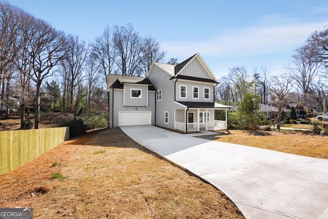 view of front of property with concrete driveway, an attached garage, fence, a porch, and board and batten siding