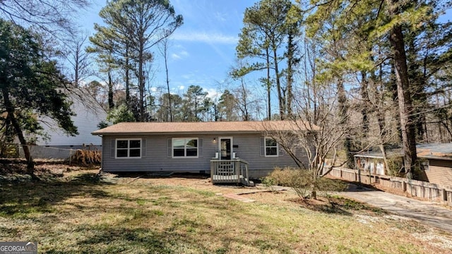 view of front of house with fence and a front lawn