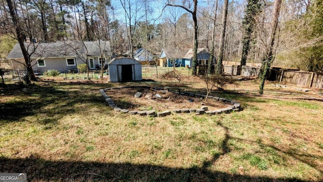 view of yard with a fenced backyard, an outdoor structure, and a storage unit