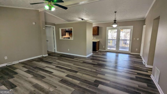 unfurnished living room with a textured ceiling, dark wood-style flooring, visible vents, and baseboards