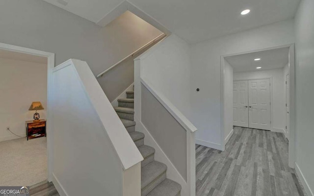 stairs with recessed lighting, baseboards, and wood finished floors