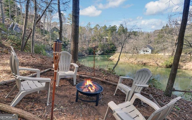 view of yard with an outdoor fire pit and a water view