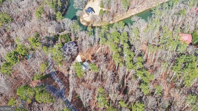 aerial view featuring a wooded view and a water view