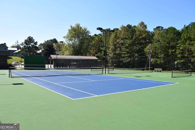 view of tennis court featuring community basketball court and fence