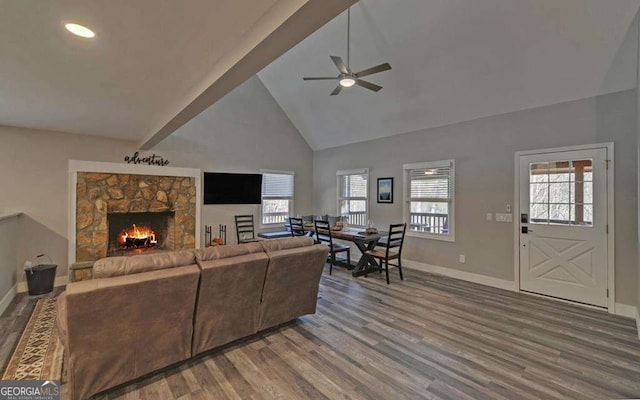 living room featuring a wealth of natural light, baseboards, high vaulted ceiling, and wood finished floors