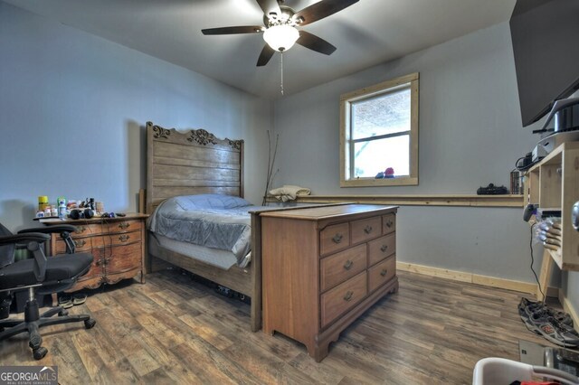bedroom with dark wood-style floors, ceiling fan, and baseboards