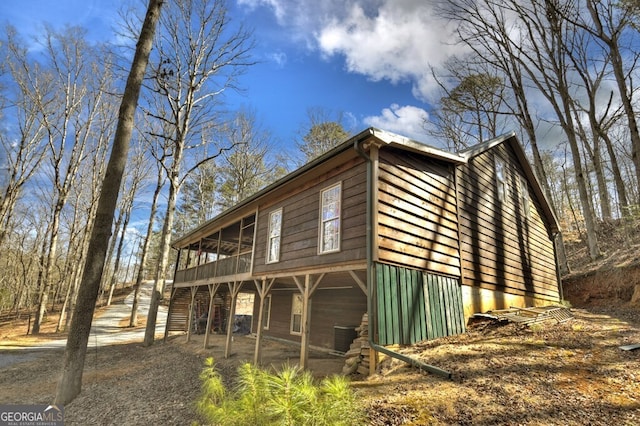 view of property exterior with central air condition unit and a sunroom