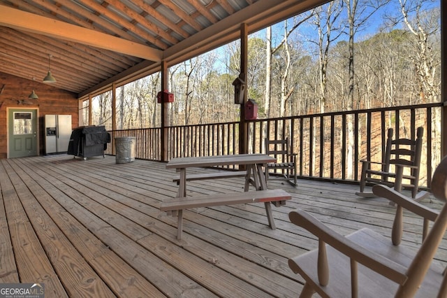 wooden terrace featuring a wooded view