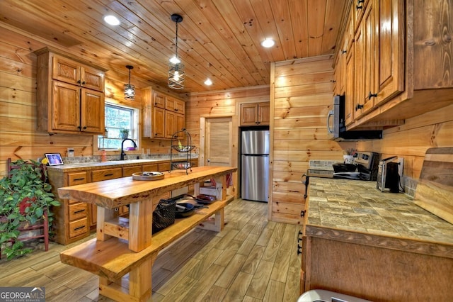 kitchen with wooden ceiling, stainless steel appliances, wood finish floors, a sink, and wood counters