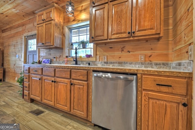 kitchen with wooden walls, visible vents, brown cabinets, and stainless steel dishwasher