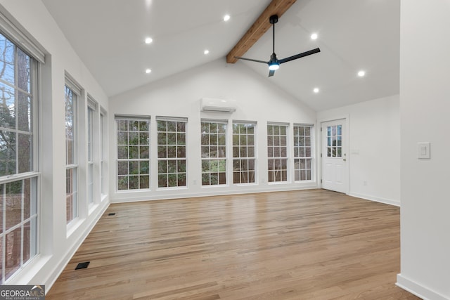 unfurnished sunroom with lofted ceiling with beams, ceiling fan, a wall mounted air conditioner, and a healthy amount of sunlight