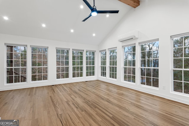 unfurnished sunroom with a ceiling fan, a wall mounted air conditioner, and vaulted ceiling with beams