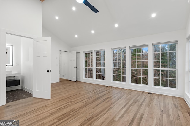 interior space with light wood finished floors, baseboards, ceiling fan, high vaulted ceiling, and recessed lighting