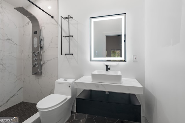 bathroom featuring vanity, a marble finish shower, and toilet