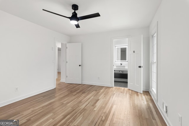 unfurnished bedroom featuring visible vents, baseboards, a ceiling fan, ensuite bathroom, and light wood-style floors