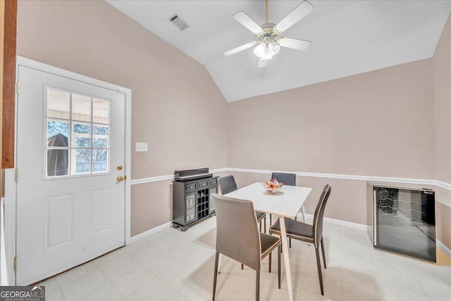 dining room featuring lofted ceiling, baseboards, visible vents, and a ceiling fan