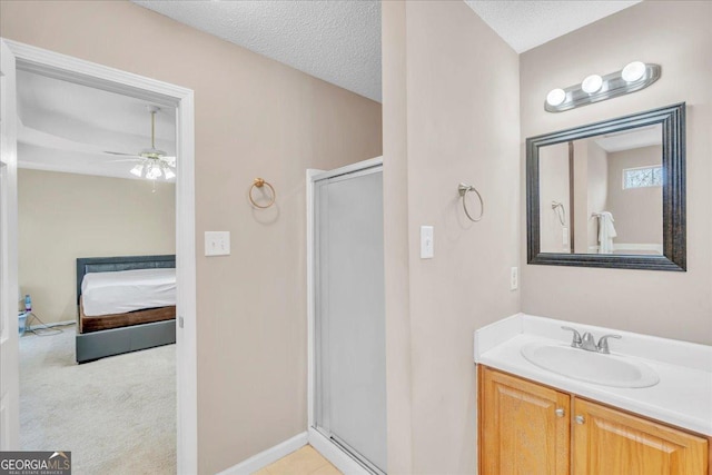 ensuite bathroom with a ceiling fan, a shower stall, ensuite bath, a textured ceiling, and vanity