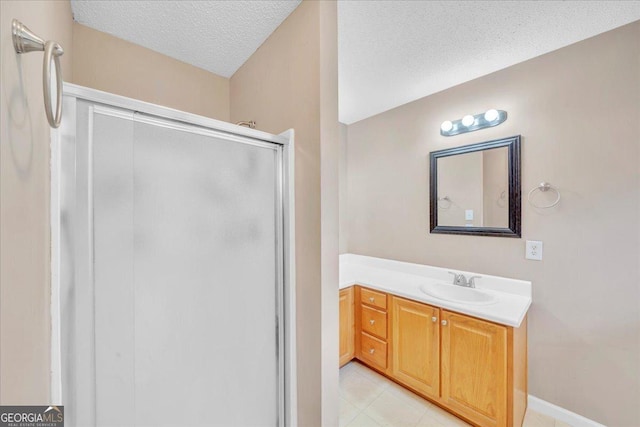 bathroom featuring a stall shower, baseboards, a textured ceiling, and vanity