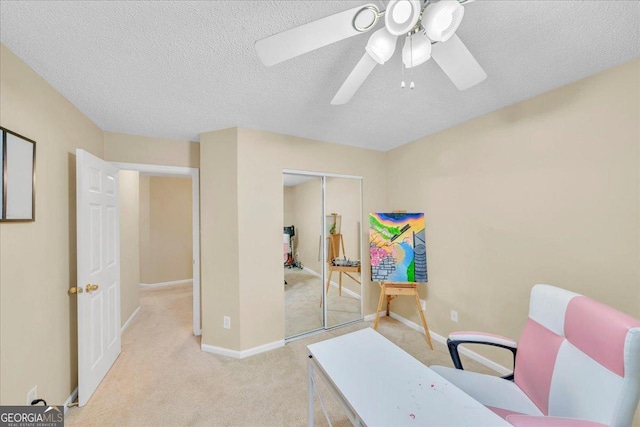 office area with light carpet, ceiling fan, a textured ceiling, and baseboards