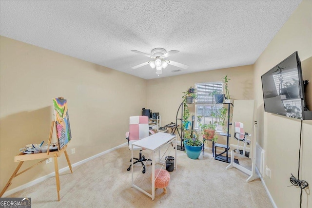 carpeted office featuring ceiling fan, a textured ceiling, and baseboards