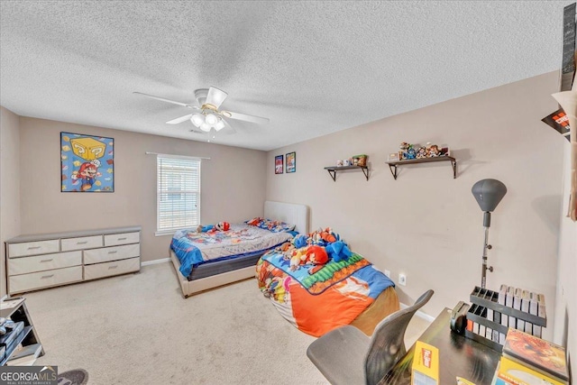 bedroom with ceiling fan, carpet floors, and a textured ceiling