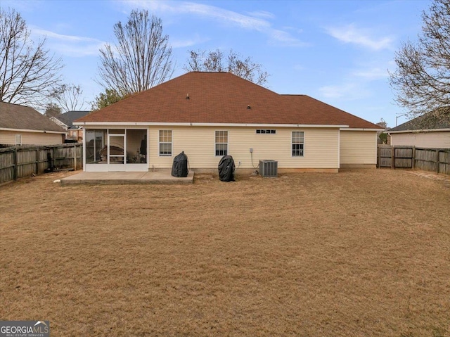 back of property with a sunroom, a fenced backyard, central AC, and a patio