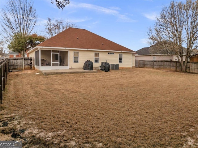 back of property with a sunroom, a fenced backyard, a yard, and a patio