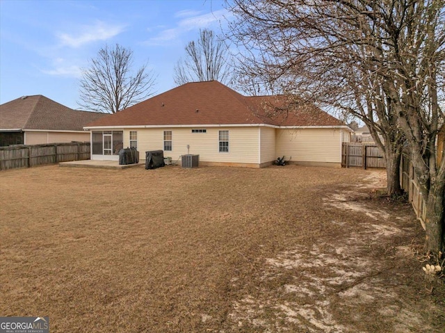 back of house with a yard, a sunroom, a patio area, cooling unit, and a fenced backyard