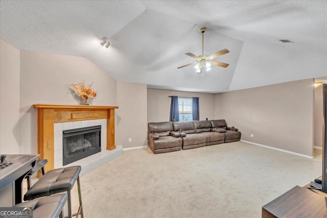 carpeted living area with lofted ceiling, a fireplace, visible vents, and baseboards