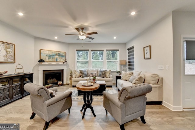 living room featuring recessed lighting, ceiling fan, baseboards, and light wood-type flooring