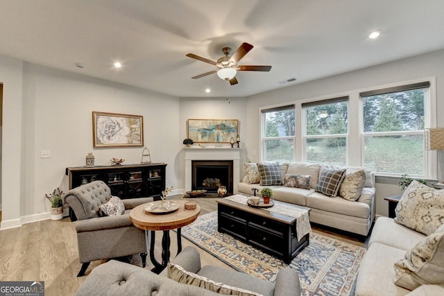 living room with visible vents, recessed lighting, a fireplace, and wood finished floors