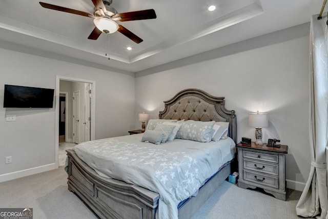 bedroom with baseboards, light colored carpet, a tray ceiling, recessed lighting, and a ceiling fan