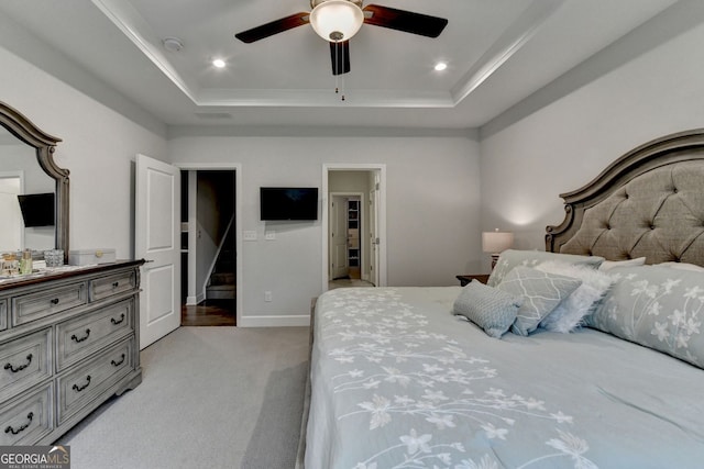 bedroom featuring crown molding, ceiling fan, light carpet, a raised ceiling, and baseboards