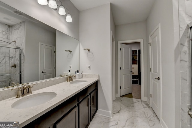 bathroom featuring baseboards, a sink, marble finish floor, and a stall shower