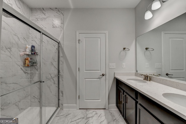 full bath with a sink, marble finish floor, a stall shower, and double vanity