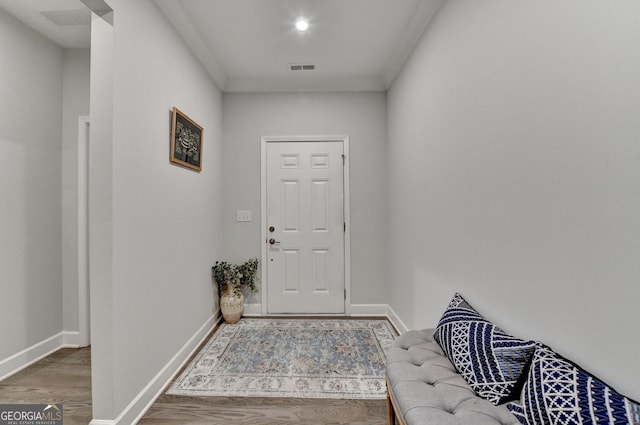doorway featuring baseboards, wood finished floors, and visible vents