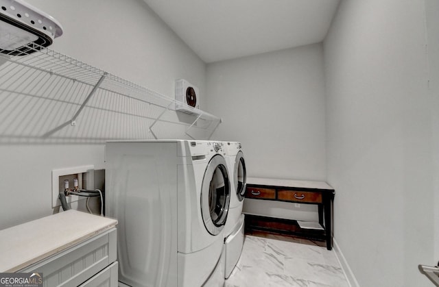 clothes washing area with laundry area, baseboards, marble finish floor, and washer and clothes dryer