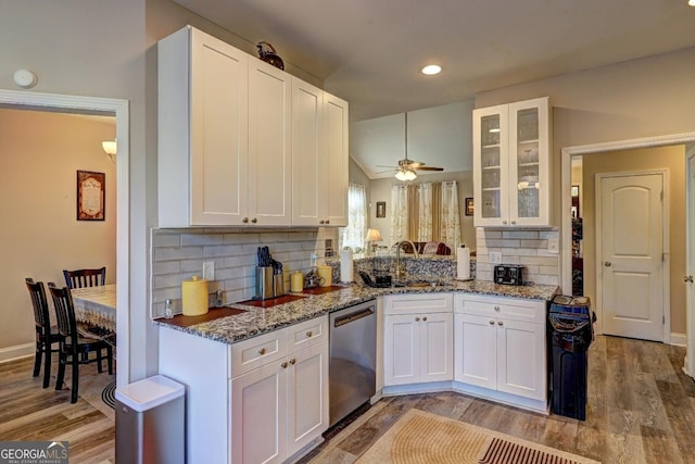 kitchen with light wood-style floors, stone countertops, white cabinetry, and stainless steel dishwasher