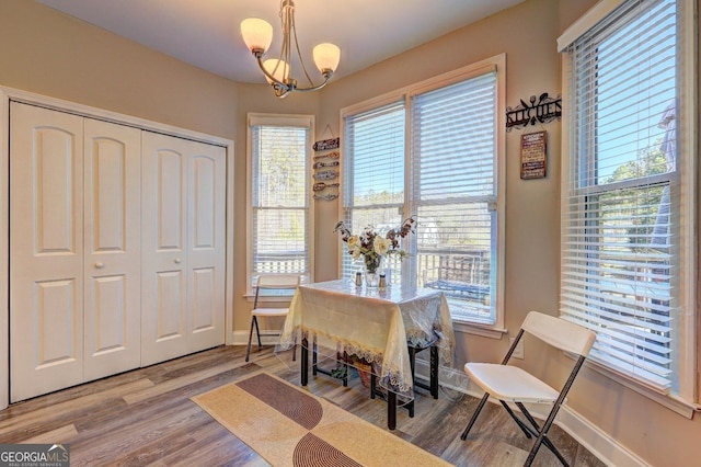 interior space with baseboards, a chandelier, and wood finished floors