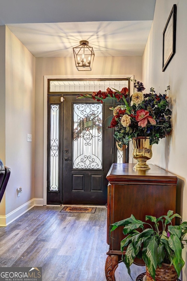 entrance foyer featuring a notable chandelier, baseboards, and wood finished floors