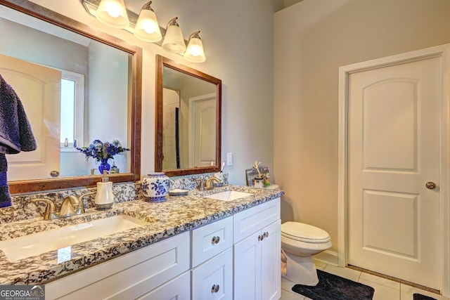 full bath featuring double vanity, tile patterned flooring, a sink, and toilet