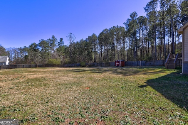 view of yard featuring an outbuilding, a shed, and a fenced backyard