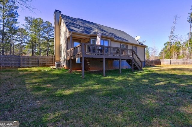 back of property with a deck, a fenced backyard, stairs, a yard, and a chimney