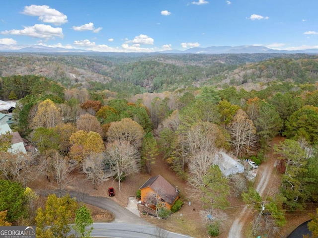 drone / aerial view with a mountain view and a view of trees