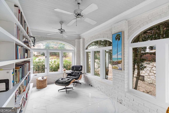 sunroom / solarium featuring a ceiling fan