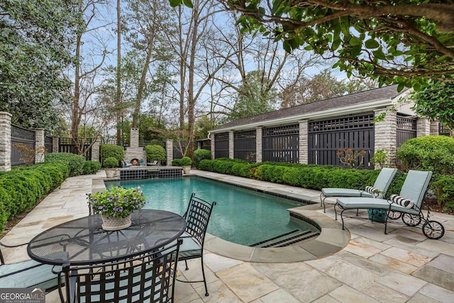 view of swimming pool featuring a patio area, outdoor dining space, a fenced in pool, and a fenced backyard