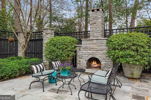 view of patio / terrace featuring an outdoor stone fireplace